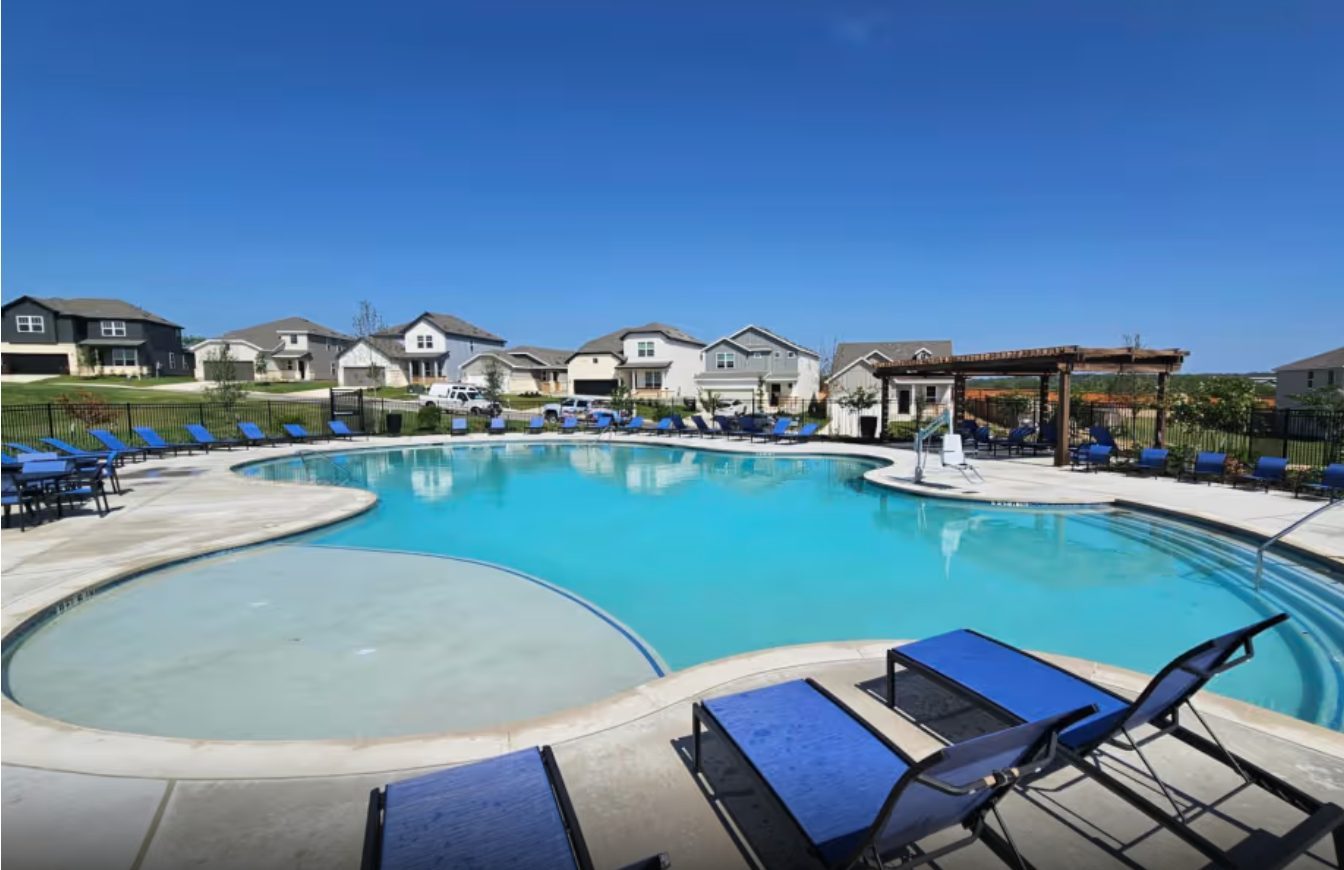 Pool court with pergola, concrete deck and the metal amenity fence.