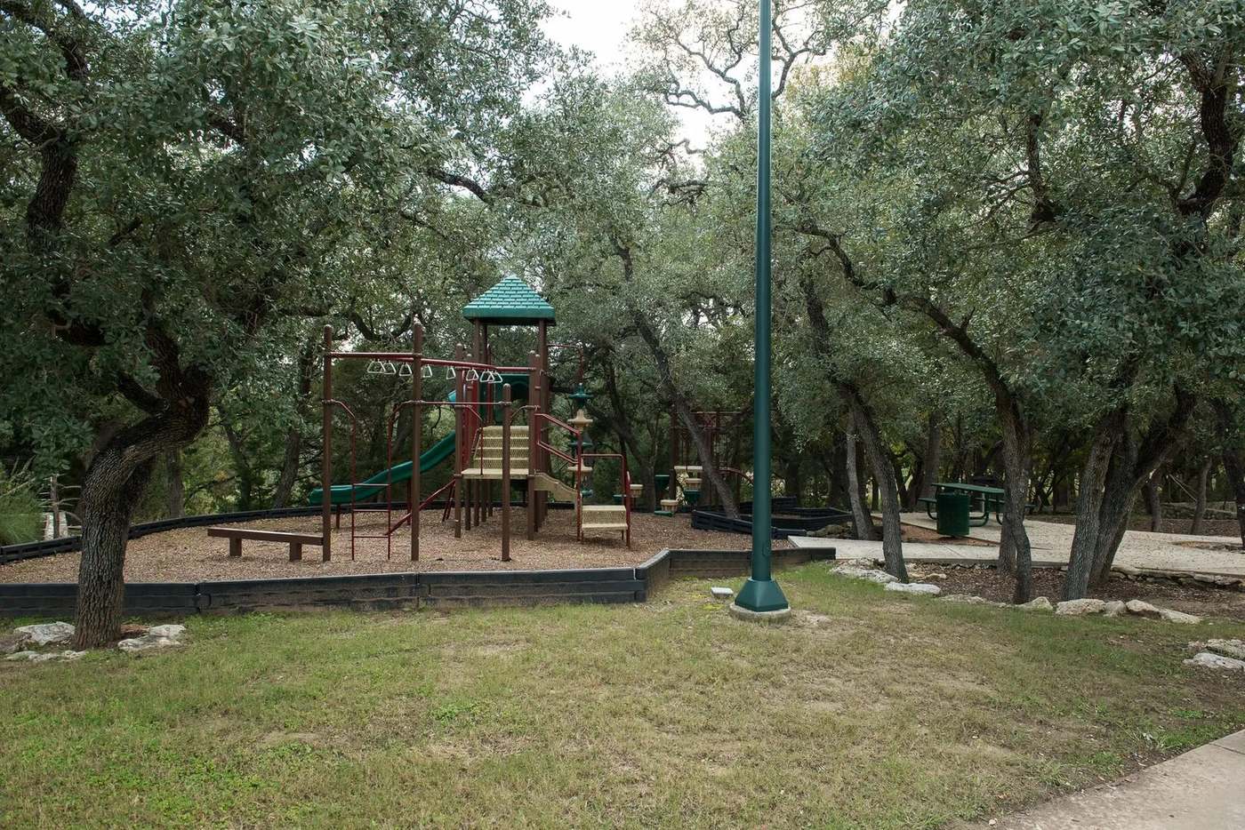 Shaded playground and picnic area under the live oaks.